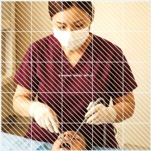 インプラント手術中にバキューム操作を行う歯科スタッフの写真